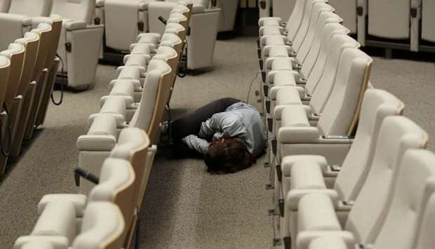 A journalist sleeps while waiting for the end of the European Union leaders summit that aims to select candidates for top EU institution jobs, in Brussels.