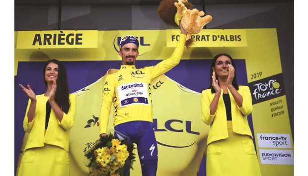 Franceu2019s Julian Alaphilippe celebrates his overall leaderu2019s yellow jersey on the podium of the fifteen stage of the 106th edition of the Tour de France yesterday. (AFP)
