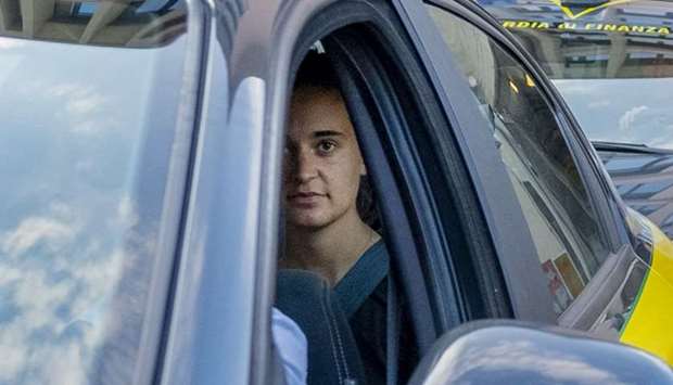 German captain of humanitarian ship Sea-Watch 3, Carola Rackete (Rear in car) looks on as she leaves in a car of the Italian Guardia di Finanza law enforcement agency yesterday after appearing before a judge at the courthouse in Agrigento, Sicily