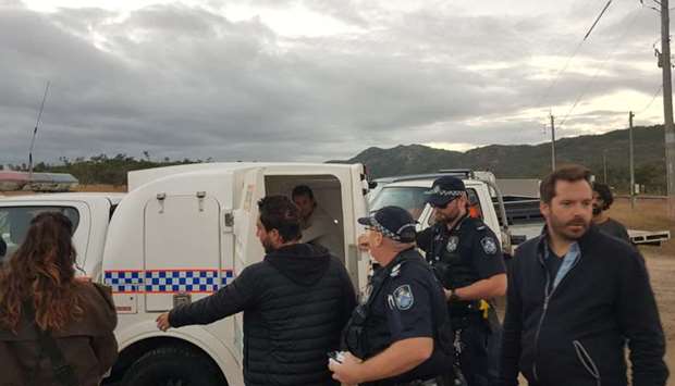 French TV reporter Hugo Clement is seen in a police van after he was arrested while filming protesters blockading the Abbot Point coal port near Bowen, Queensland, Australia