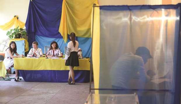 A man fills in his ballot inside a voting booth at a polling station in the village of Mshana, some 15km from the western city of Lviv, during Ukraineu2019s parliamentary election.