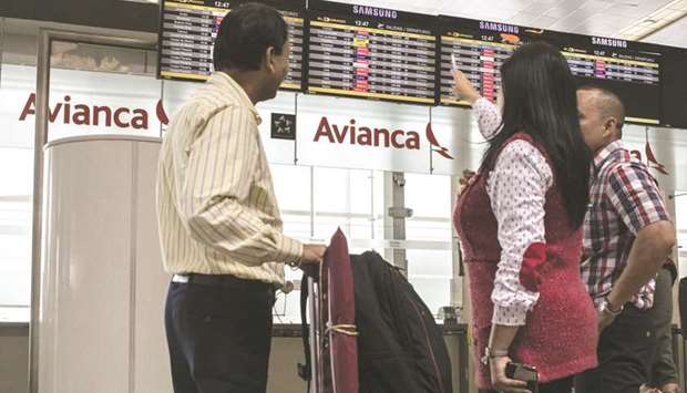 Travellers view monitors displaying the departure schedule for flights next to Avianca Holdings signage at El Dorado International Airport in Bogota, Colombia (file).