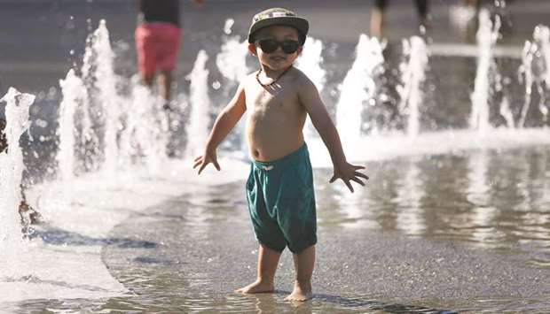 A boy cools off at a fountain in Los Angeles on Sunday afternoon.