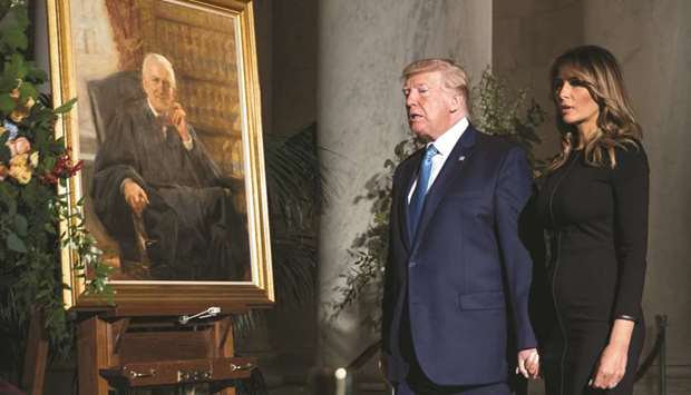 President Donald Trump and First Lady Melania Trump walk past a painting of the late Supreme Court Justice John Paul Stevens as he lies in repose in the Great Hall of the Supreme Court in Washington.