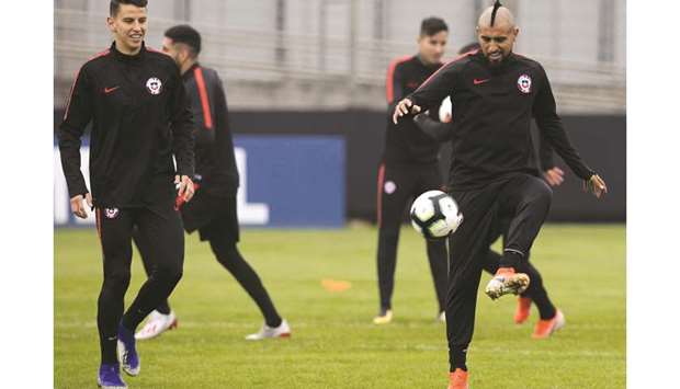 Chileu2019s midfielder Arturo Vidal (right) and defender Igor Lichnovsky take part in a training session in Porto Alegre, Rio Grande do Sul, Brazil, on the eve of their Copa America semi-final against Peru. (AFP)