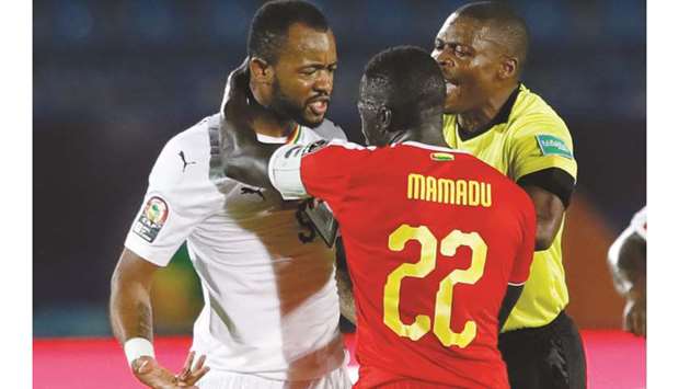 Gabonese referee Eric Castane (right) separates Ghanau2019s forward Jordan Ayew (left) and Guinea-Bissauu2019s defender Mamadu Cande after the two players clashed during the Africa Cup of Nations Group F match at the Suez Stadium in the north-eastern Egyptian city yesterday. (AFP)