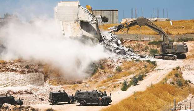 Israeli security forces tear down one of the Palestinian buildings in the West Bank village of Dar Salah, adjacent to the Sur Baher area which straddles the Israeli-occupied West Bank and Jerusalem.