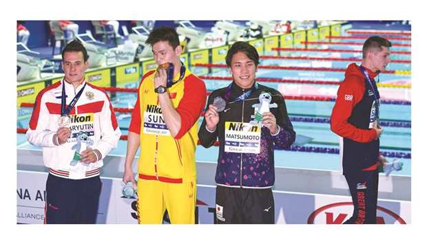 Gold medallist Sun Yang (second from left) of China, silver medallist Katsuhiro Matsumoto (second from right) of Japan and joint bronze medallist Martin Malyutin (left) pose on the menu2019s 200m freestyle podium as the other joint bronze medallist Duncan Scott (right) of Britain walks off at the 2019 World Championships in Gwangju, South Korea, yesterday. (AFP)