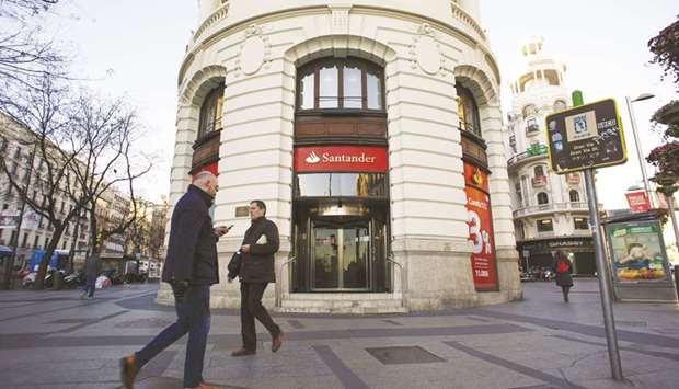 Pedestrians pass a Banco Santander branch in Madrid.