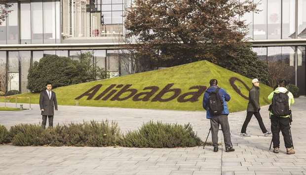 Members of the media film signage for Alibaba Group Holding at the companyu2019s headquarters during a government-organised tour in Hangzhou, China.