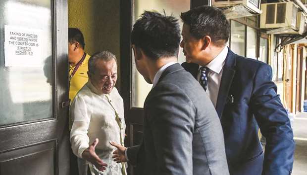 Theodore Te (left), former Philippine Supreme Court spokesman and lawyer for journalist Maria Ressa, shakes hands with prosecution attorneys Ryan Cruz (right) and Joseph Banguis (centre) after the start of Ressau2019s trial in Manila yesterday.