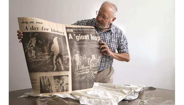 THE MOMENT: Glen Williams, 65, opens up his preserved original, Monday, July 21, 1969 historic edition of the Chicago Daily News front page story on the moon landing, at the Chicago Tribune newspaper office, Friday, July 19, 2019.