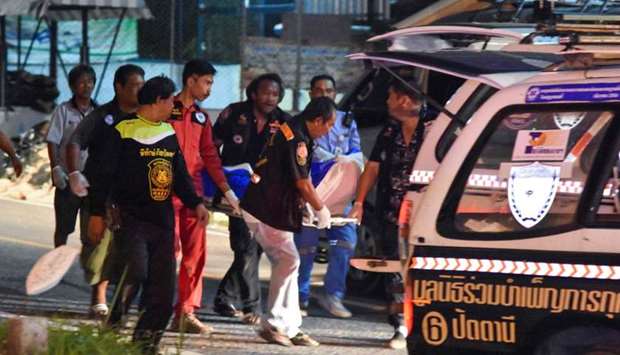 Rescue workers rush a victim to an ambulance following an attack by militants at a military checkpoint in Pattani yesterday.
