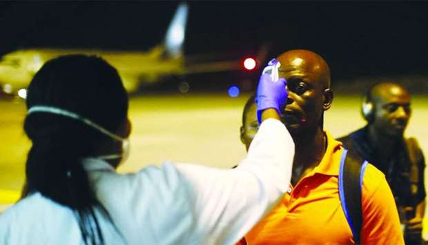 A health worker checks the temperature of a man arriving at Bata Airport in Litoral, Equatorial Guinea.