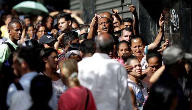 Venezuelan citizens line up to buy food at a store in Caracas, Venezuela