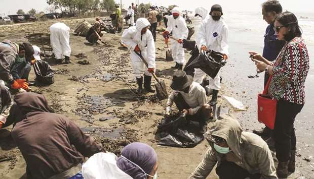 Officials and local fishermen clean the shore at Cemara Beach in Karawang, West Java province.