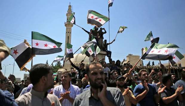 Syrian men wave rebel flags as they demonstrate in Azaz, north of Aleppo.
