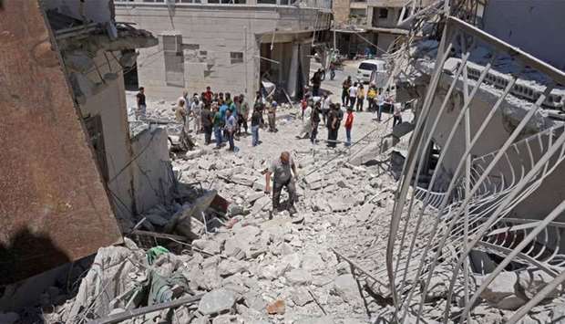 Syrians gather at the site of a reported air strike on the town of Ariha