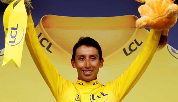 Team INEOS rider Egan Bernal of Colombia celebrates on the podium, wearing the overall leader's yellow jersey