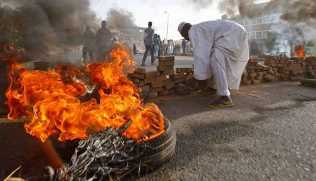 Sudanese protesters block a street with bricks and burning tires as military forces attempted to disperse the ongoing sit-in outside Khartoum's army headquarters on June 3.