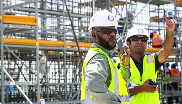 Workers at Al Rayyan Stadium oversee the construction progress.