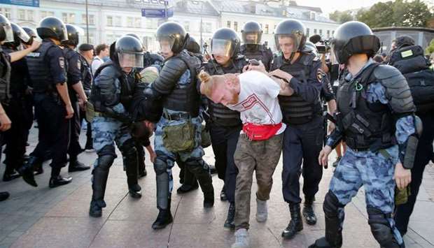 Riot police officers detain protesters during an unauthorised rally demanding independent and opposition candidates be allowed to run for office in local election in September, at Moscow's Trubnaya Square