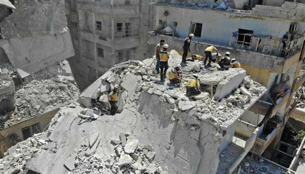 Members of the Syrian Civil Defence (White Helmets) search for victims at the site of a reported air strike on the town of Ariha, in the south of Syria's Idlib province on July 27. AFP