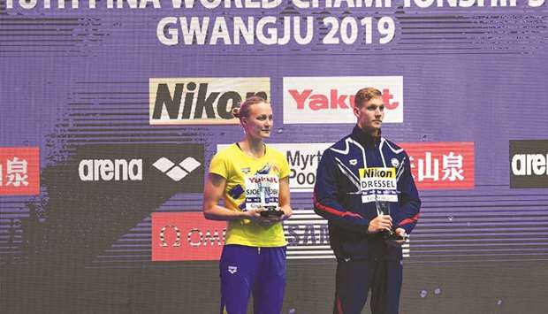 Swedenu2019s Sarah Sjostrom (left) and Caeleb Dressel of the US hold their trophies for best womenu2019s and menu2019s swimmer at the 2019 World Championships in Gwangju, South Korea, on Sunday. (AFP)