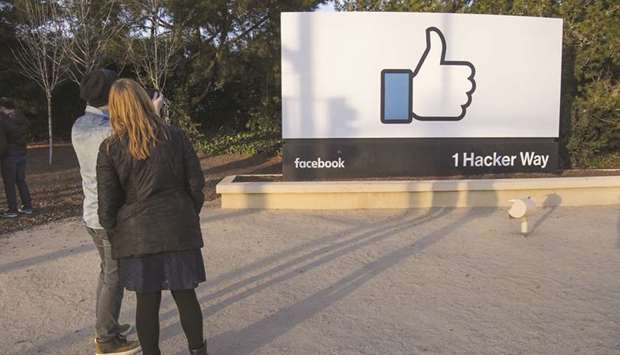 Pedestrians take photographs of signage displayed outside Facebook headquarters in Menlo Park, California (file).