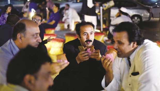 People gather to drink tea in small clay pots at a market in Islamabad.