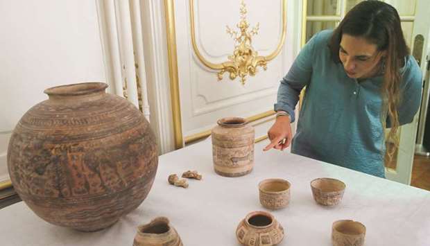 Archaeologist Aurore Didier points to some artifacts amongst the 445 artifacts from the 2nd and 3rd millennium BC which were seized by French customs between 2006 and 2007, before being returned by French authorities to Pakistan, during a ceremony at the Pakistan embassy in Paris, yesterday.