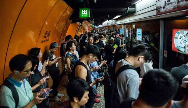 Commuters line up on a Mass Transit Railway (MTR) platform in Hong Kong after MTR services were resumed after being suspended by protesters demonstrating against a controversial extradition bill.