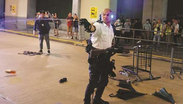 A police officer uses a pepper spray during clashes with anti-extradition bill protesters who surrounded a police station where detained protesters are being held in Hong Kong, yesterday.