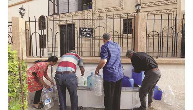 People fill gallons with water during a water shortage in Tripoli, Libya, in this June 13, 2019 photograph.