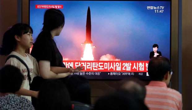 People watch a TV that shows a picture of a North Korean missile for a news report on North Korea firing short-range ballistic missiles, in Seoul