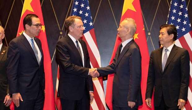Trade Representative Robert Lighthizer shakes hands with Chinese Vice Premier Liu He as US Treasury Secretary Steven Mnuchin and China's Commerce Minister Zhong Shan look on during a family photo at the Xijiao Conference Center in Shanghai, China