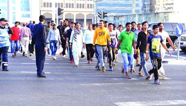 Officials guiding pedestrians to safely cross the road during an awareness building campaign.