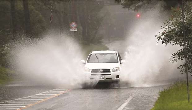 A car splashes through large puddles caused by downpours in Miyazaki, southwestern Japan, in this photo taken by Kyodo.