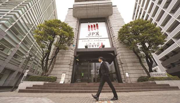 A pedestrian walks past the Tokyo Stock Exchange building. Japanese stocks rose 0.3% to 21,702.45 points yesterday.