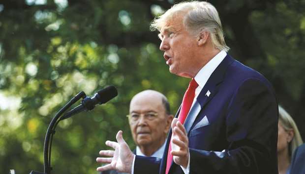 US President Donald Trump announces the US-Mexico-Canada Agreement (USMCA) as US Commerce Secretary Wilbur Ross looks on during a news conference in the Rose Garden of the White House in Washington, on October 1.