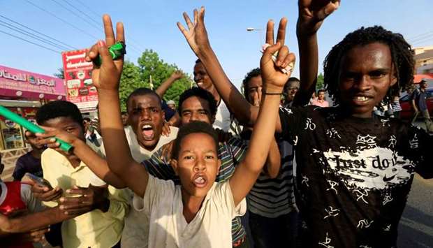 Sudanese people chant slogans as they celebrate, after Sudan's ruling military council and a coalition of opposition and protest groups reached an agreement to share power during a transition period leading to elections, along the streets of Khartoum