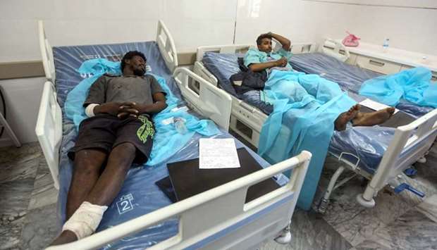 Injured migrants lie on hospital beds at a medical emergency ward in a hospital in the capital Tripoli on July 3, following an air strike on a nearby building that left dozens killed the previous night.