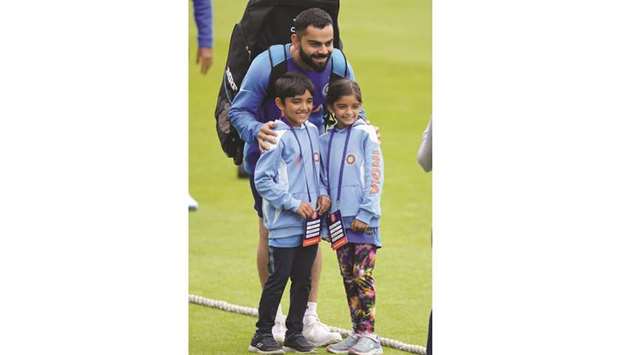 Indiau2019s captain Virat Kohli poses for a photograph with young fans during a training session at Headingley Stadium in Leeds, northern England, yesterday. (AFP)