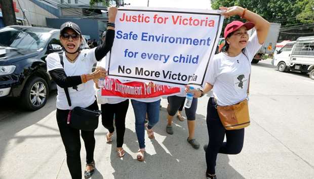 Protesters hold signs during a march demanding justice for a child rape case, in Yangon, Myanmar