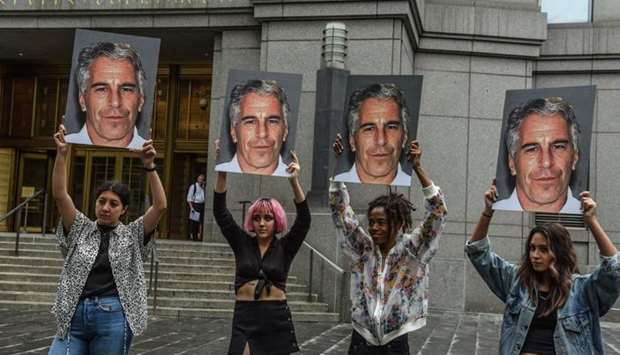 A protest group called ,Hot Mess, hold up signs of Jeffrey Epstein in front of the federal courthouse in New York City.