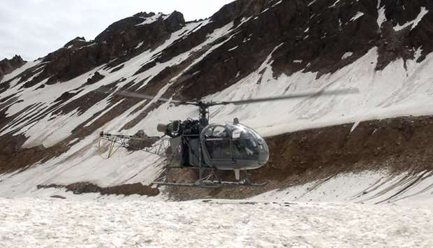 In this handout photo taken and released by the Indo Tibetan Border Patrol (ITBP) on July 3, a helicopter being used to retrieve the bodies of mountaineers from Nanda Devi is pictured at base camp on the mountain before carrying the remains down to Pithoragarh in the Indian state of Uttarakhand.