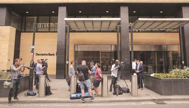 Members of the media gather outside the offices of Deutsche Bank in London after the bank announced a sweeping turnaround plan, radically shrinking and reshaping its global operations.