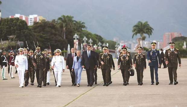 Venezuelau2019s President Nicolas Maduro walks next to his wife Cilia Flores, Defence Minister Vladimir Padrino Lopez and military commanders during a military graduation ceremony in Caracas, Venezuela.