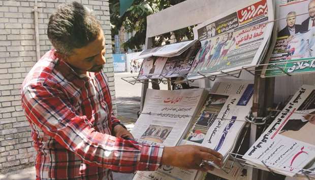 An Iranian man checks the headlines of local newspapers in Tehran, yesterday.