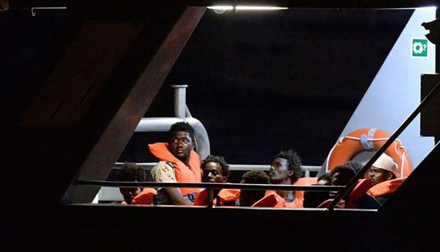 Migrants, part of group of 65 rescued by the German-flagged NGO rescue ship Alan Kurdi, look out from a patrol boat as they are brought into Haywharf, in Valletta, by the Armed Forces of Malta after being transferred onto the Maltese patrol boat on July 7.